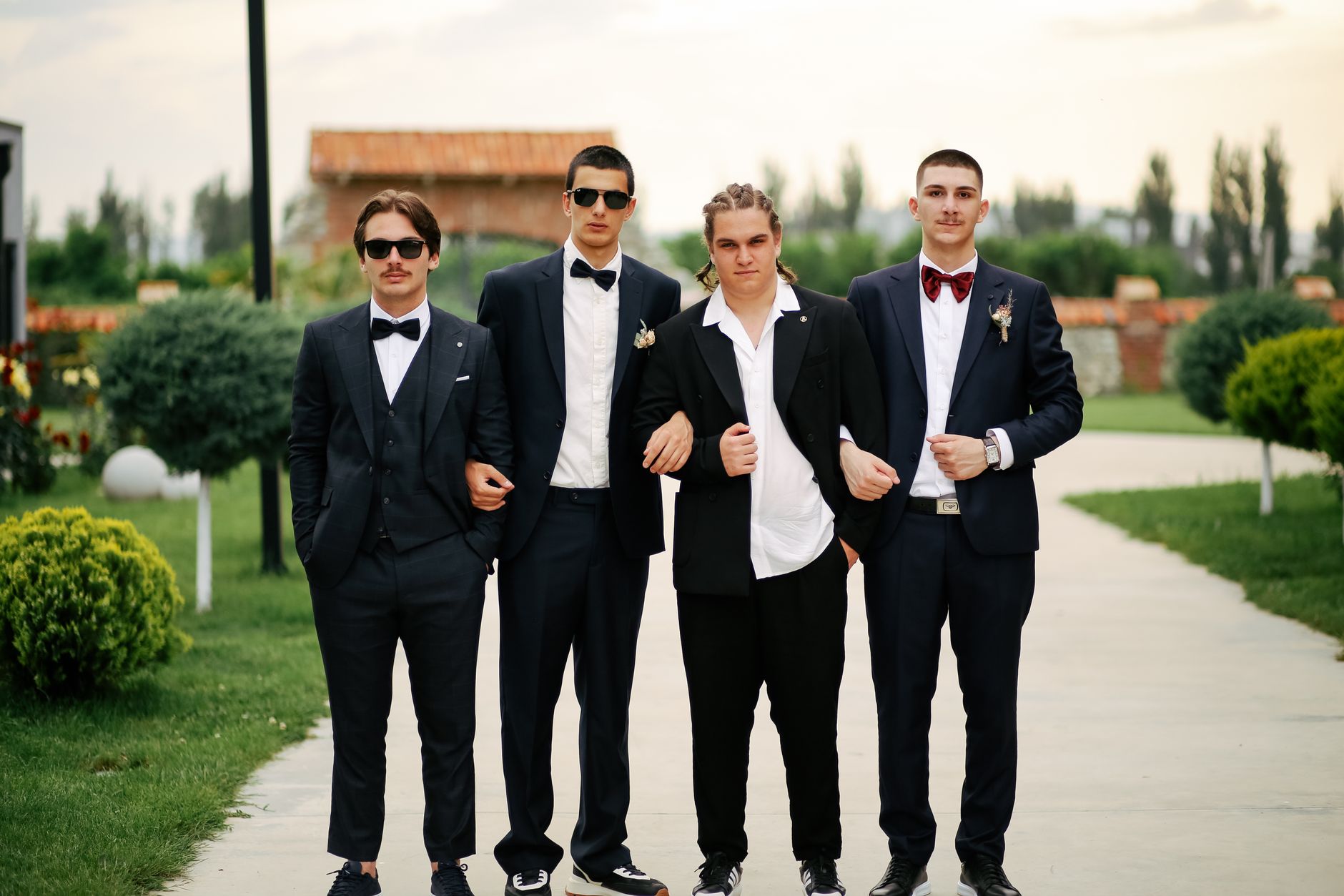 Wedding guests in black tie attire, a tuxedo with black bow tie and a floor-length gown