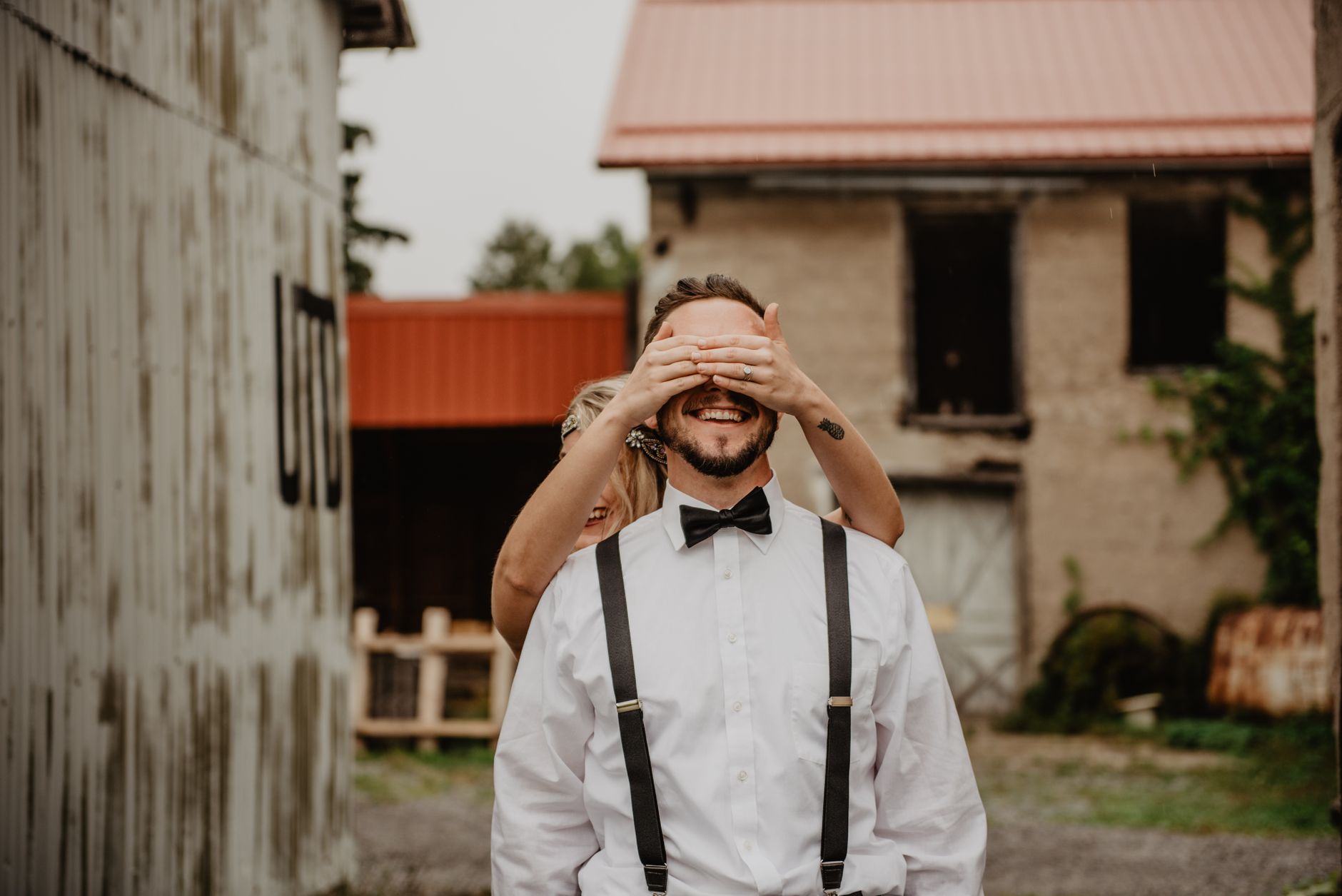 Man in white shirt, brown leather suspenders and dark denim as country wedding attire for men