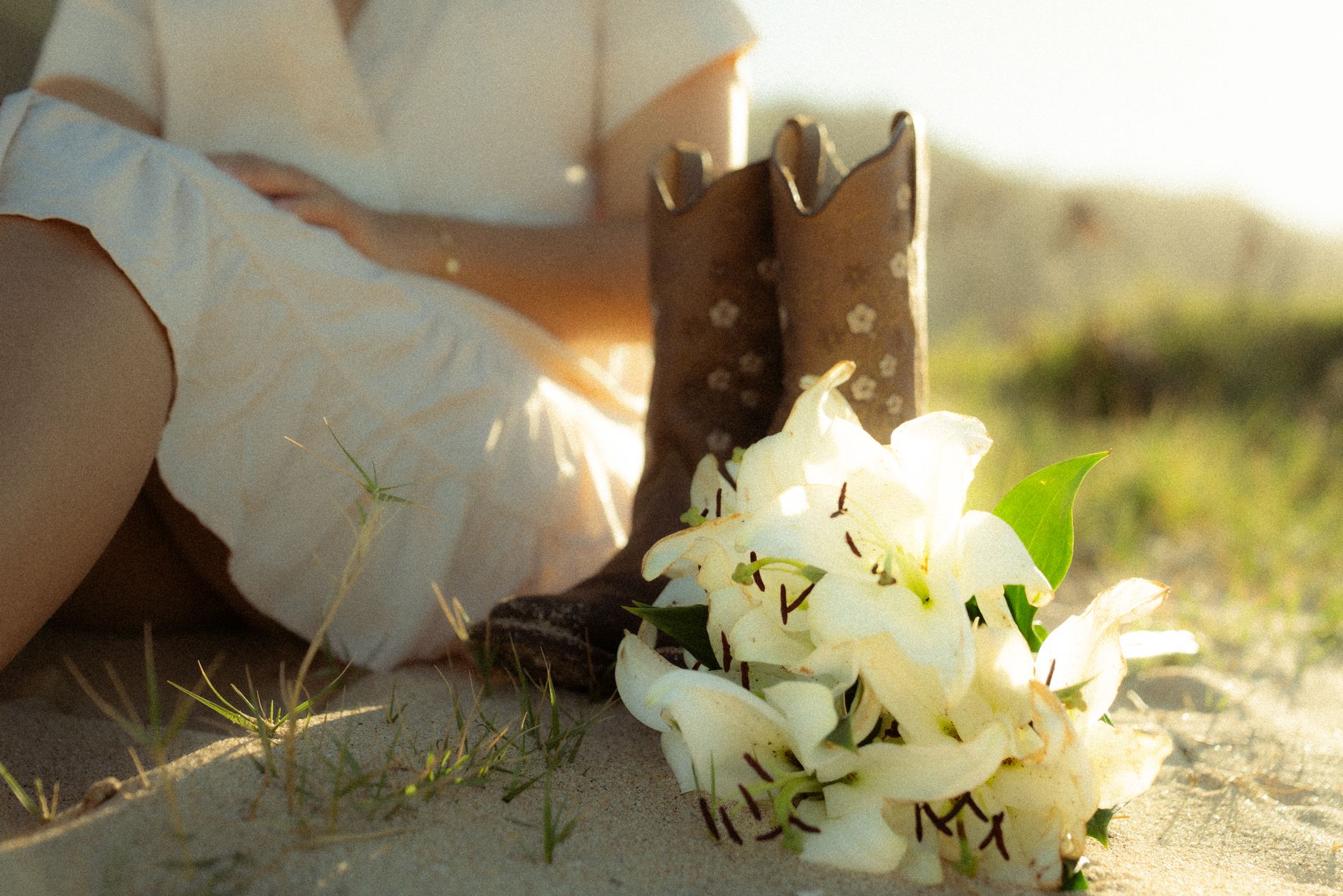 Female wedding guest in floral midi dress and cowboy boots for country wedding attire