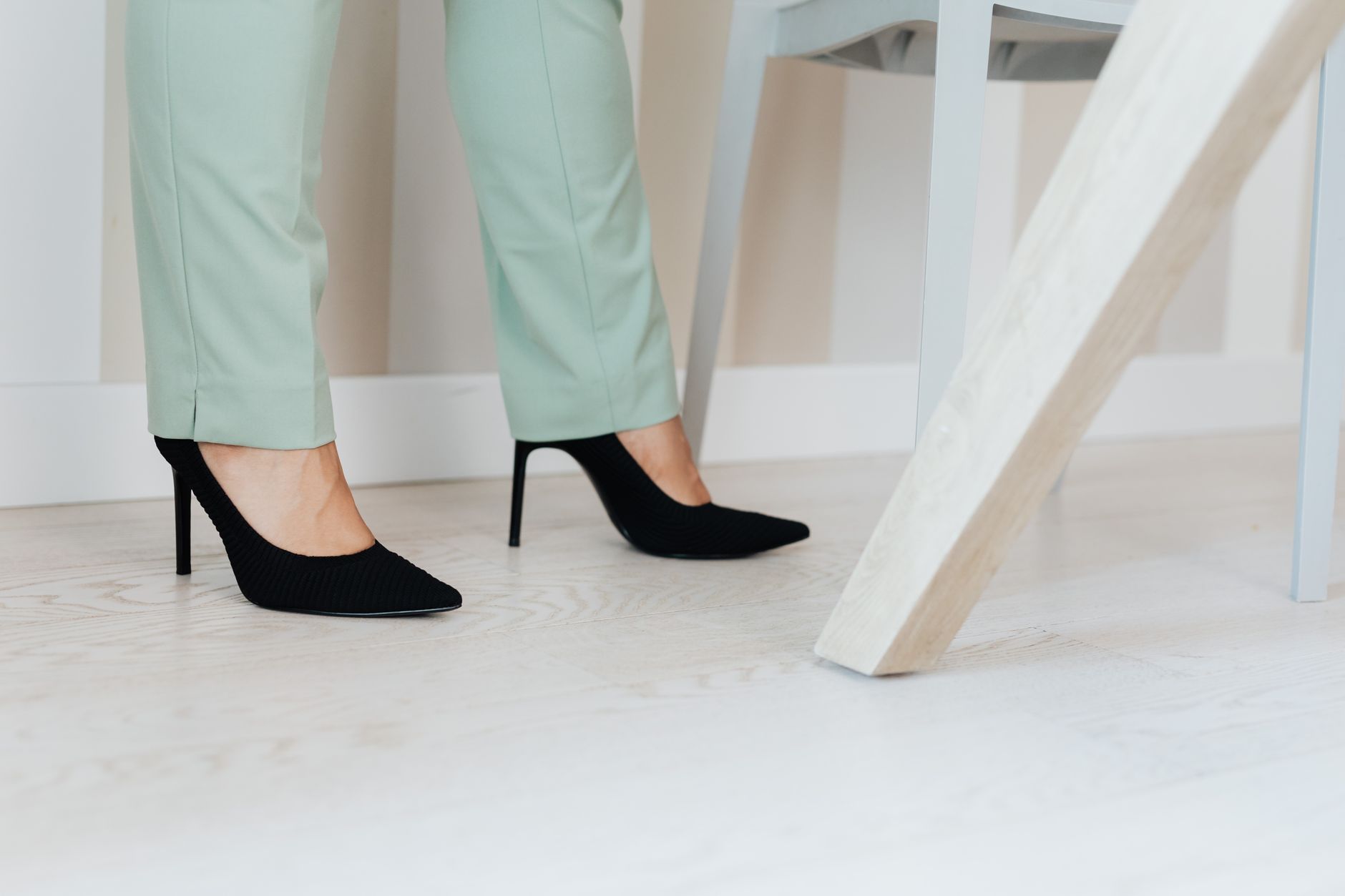 Woman in a cream blouse and tailored black trousers dressed business casual