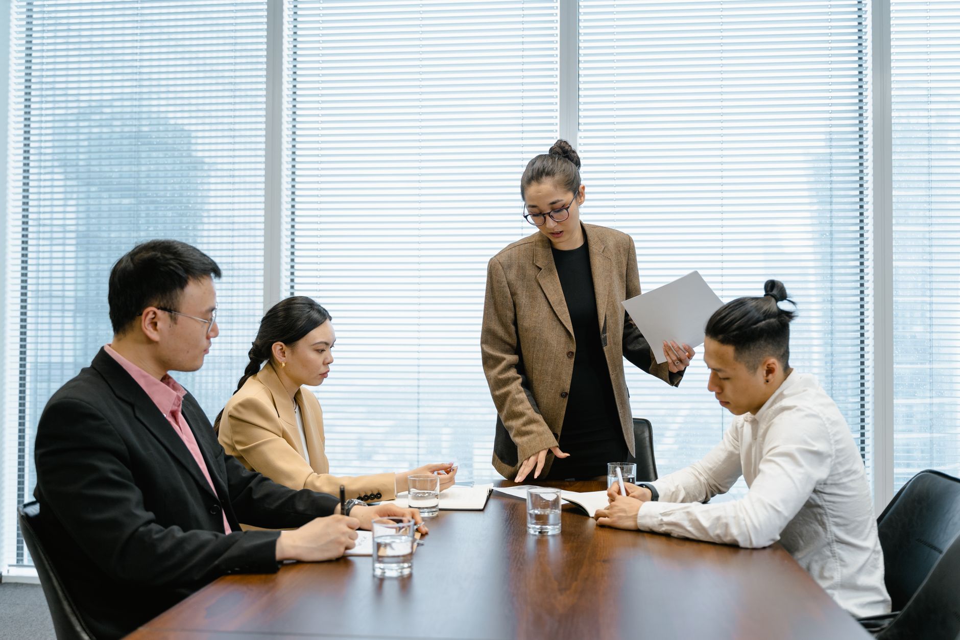 Professionals in business casual attire meeting a client in a conference room