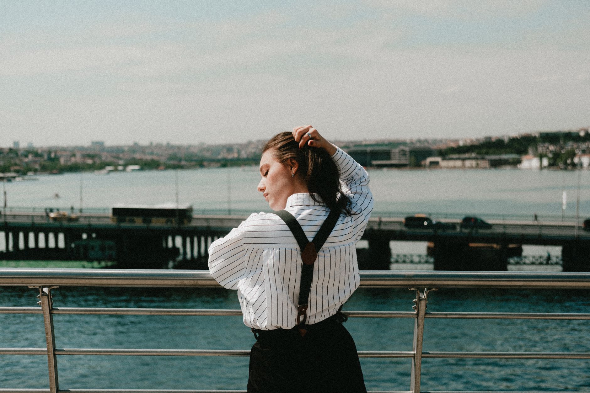 Silk blouse styled with slim suspenders and high-waisted trousers
