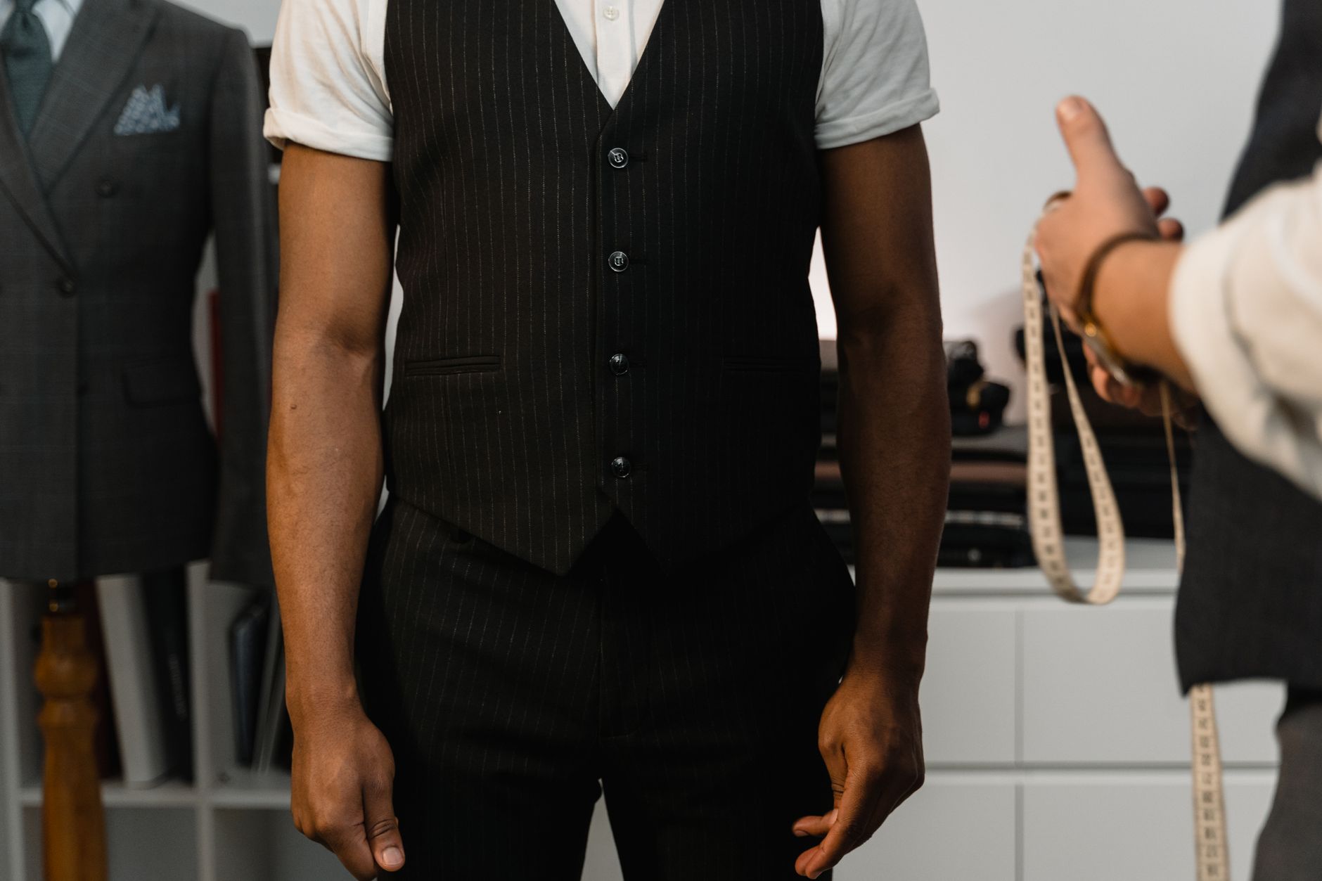 Charcoal pinstripe three-piece suit styled with suspenders and a tie bar