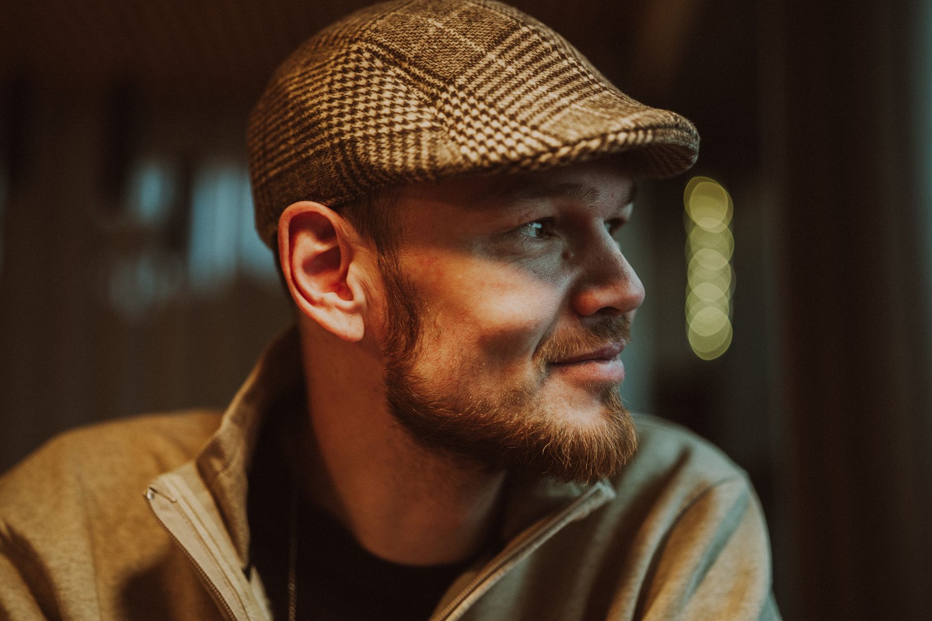 Tweed newsboy cap, waistcoat and braces over a collarless shirt