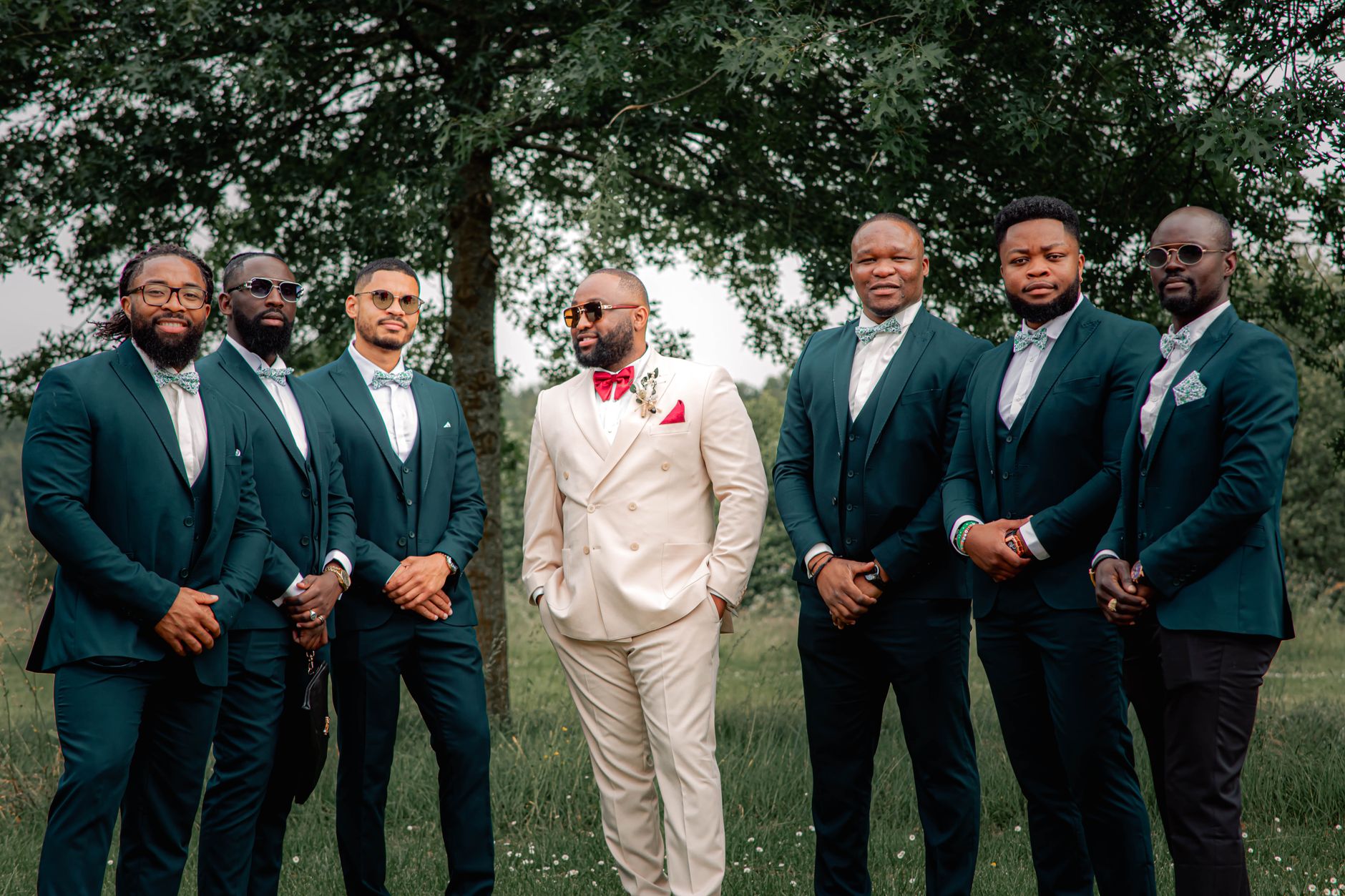Groom and groomsmen in coordinated suits and braces before a wedding