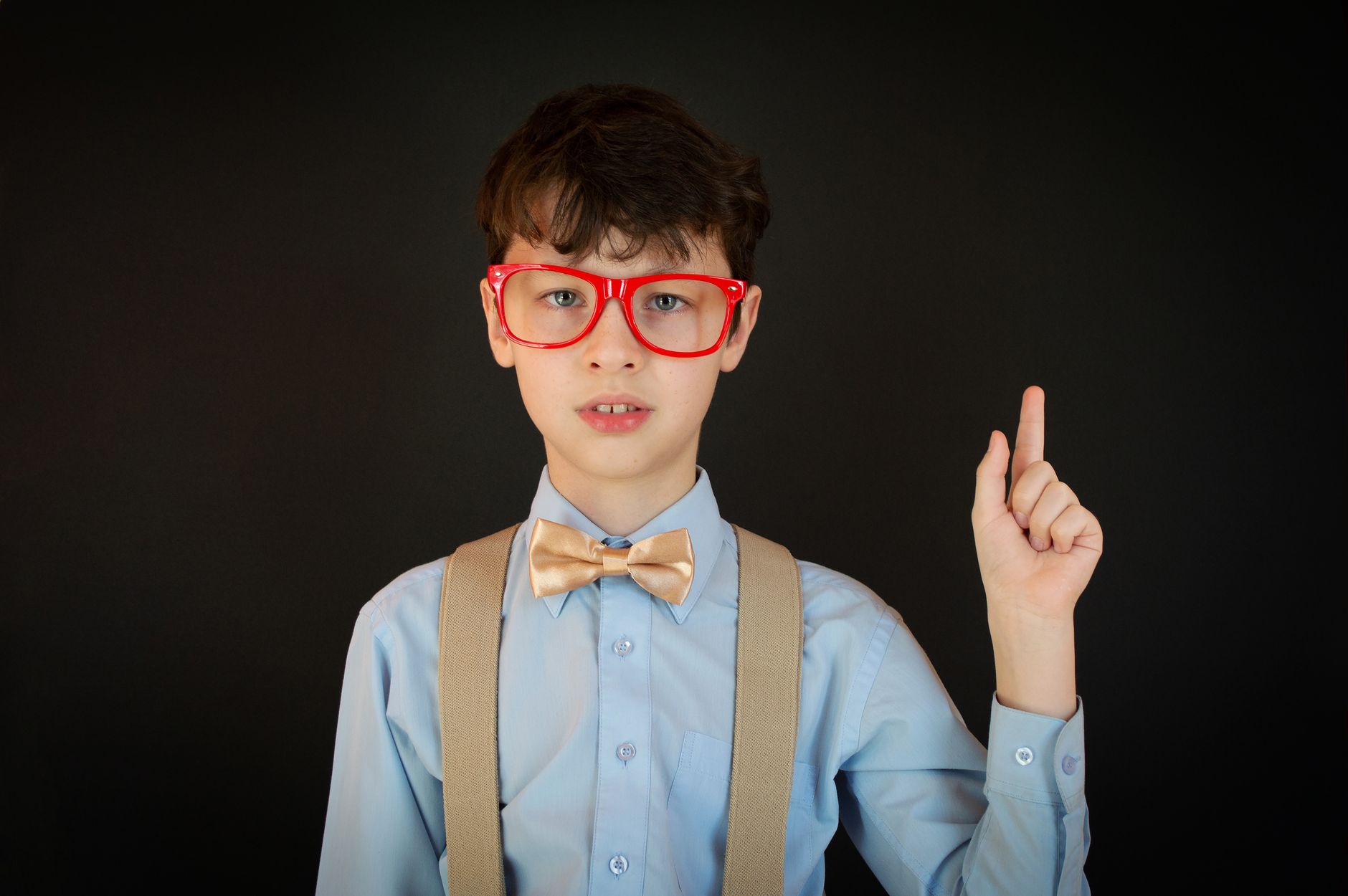 Boy wearing bright patterned suspenders with a bow tie