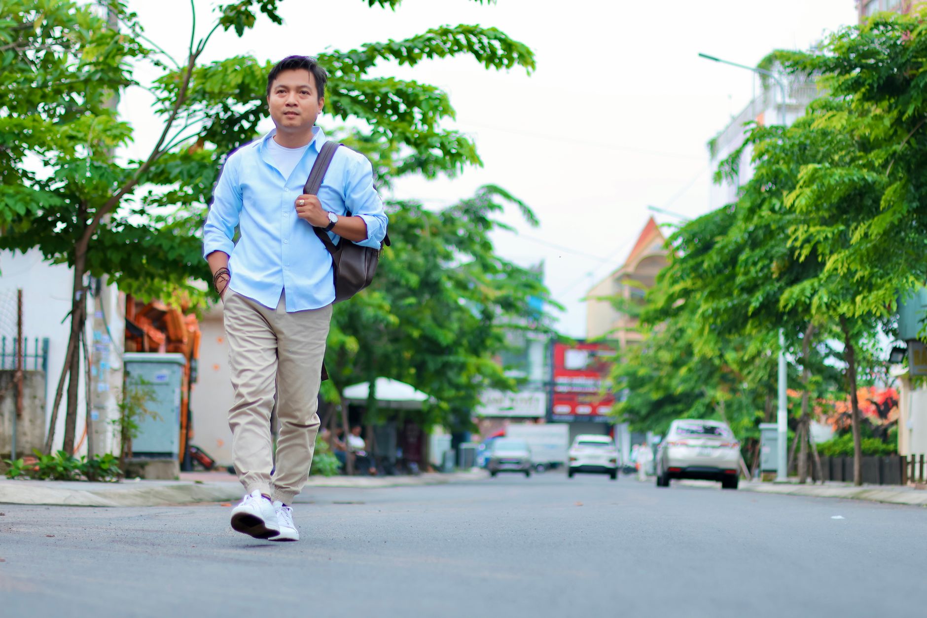 Light blue button-up shirt tucked into khaki chinos with a brown leather belt