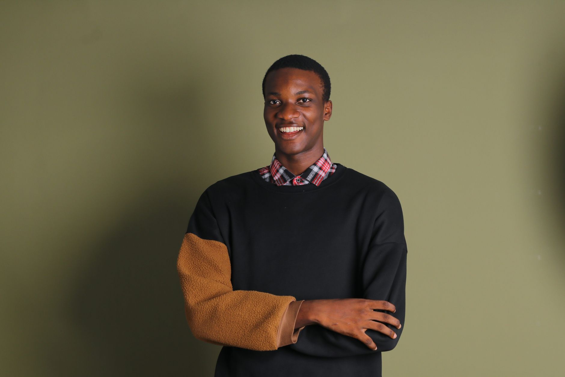 Charcoal merino sweater layered over a striped collared shirt with wool trousers