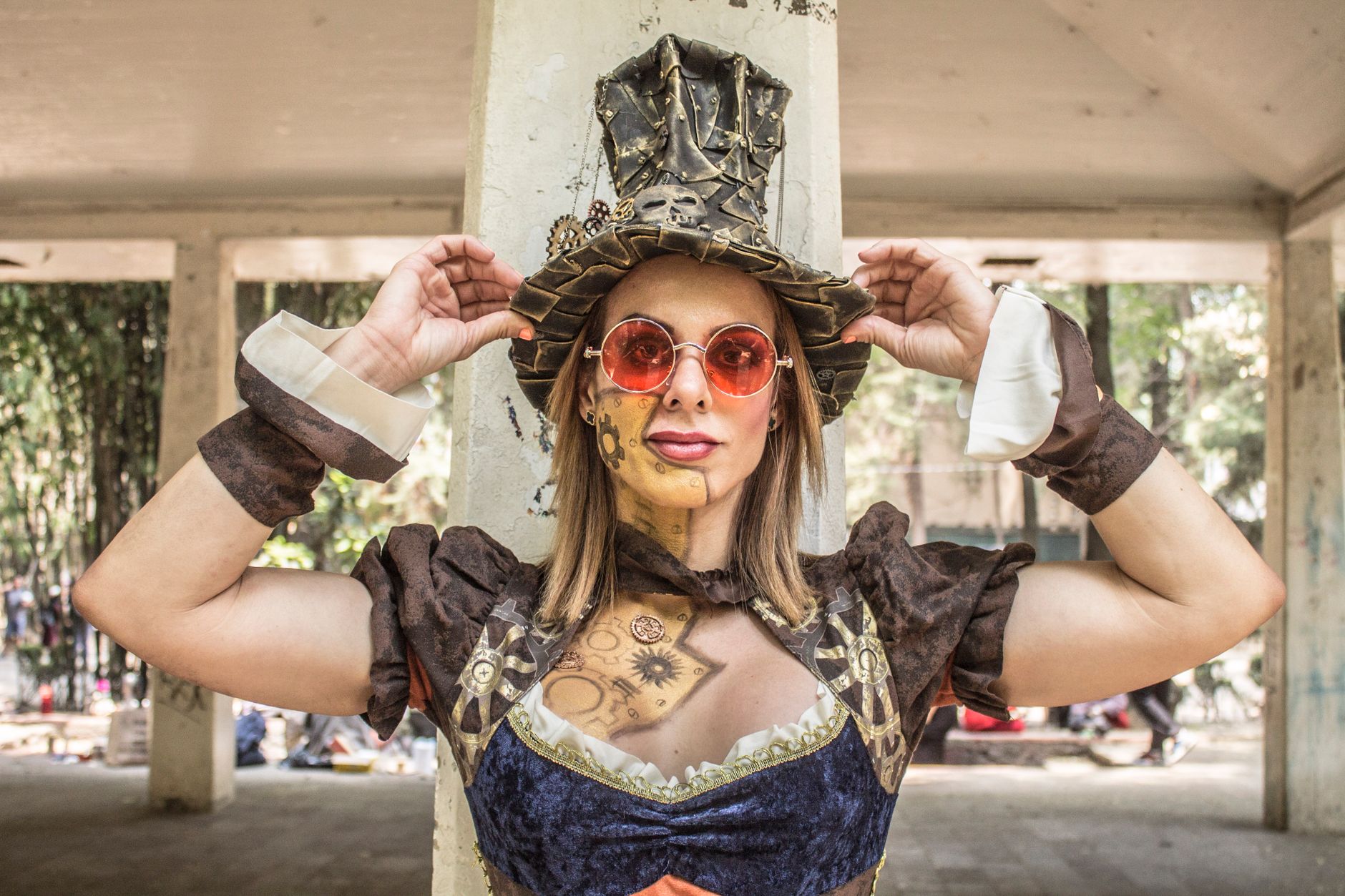 Steampunk woman in an underbust corset, bustle skirt and mini top hat with gears