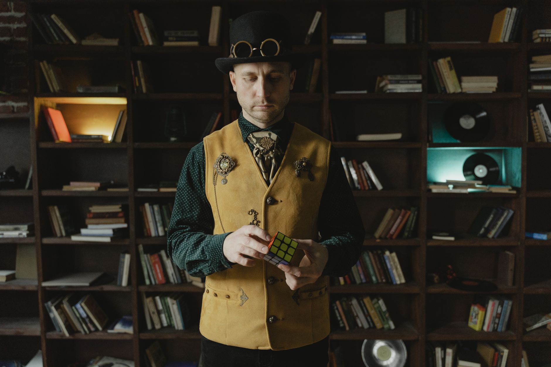 Man in a brown waistcoat, cream shirt and suspenders with brass goggles on his forehead