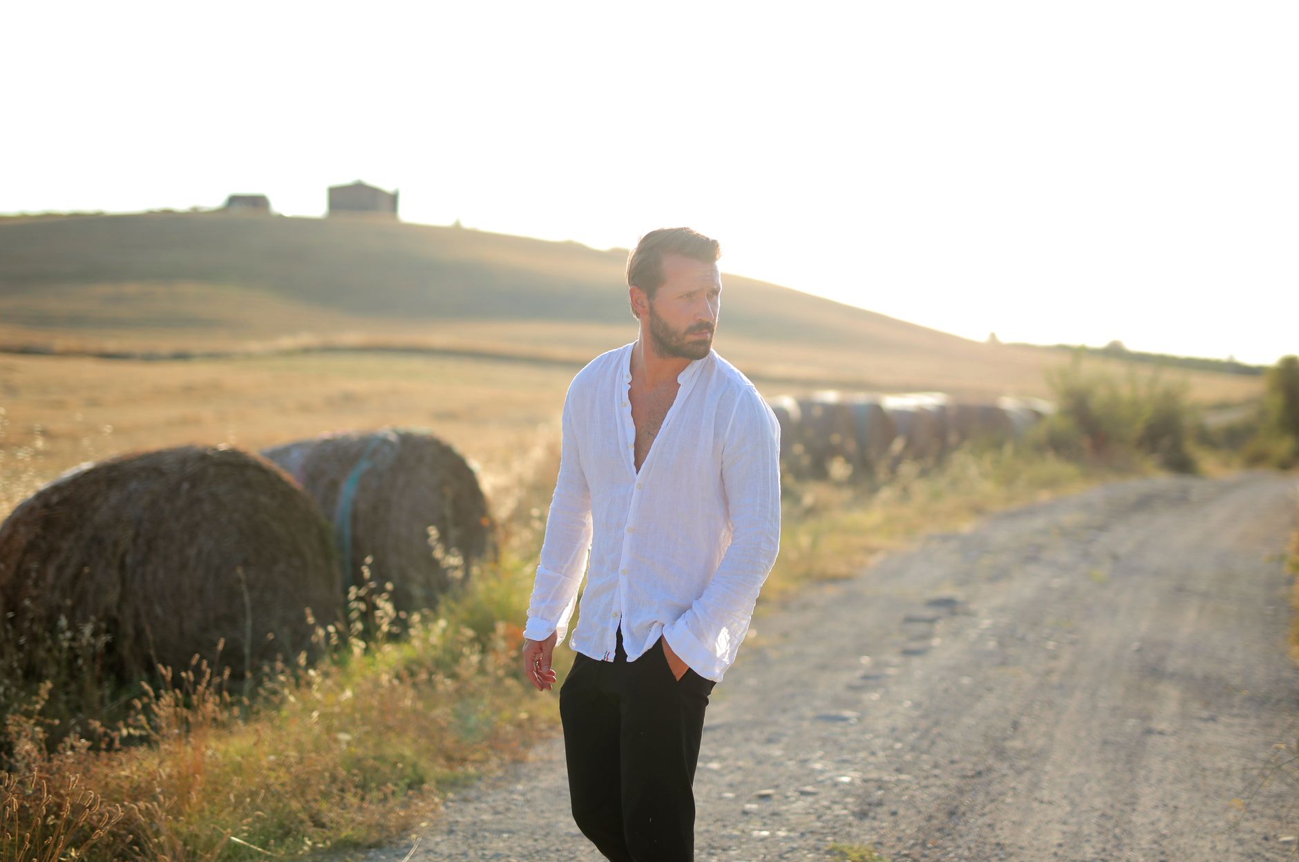 Man wearing a white linen shirt with navy chinos and brown penny loafers