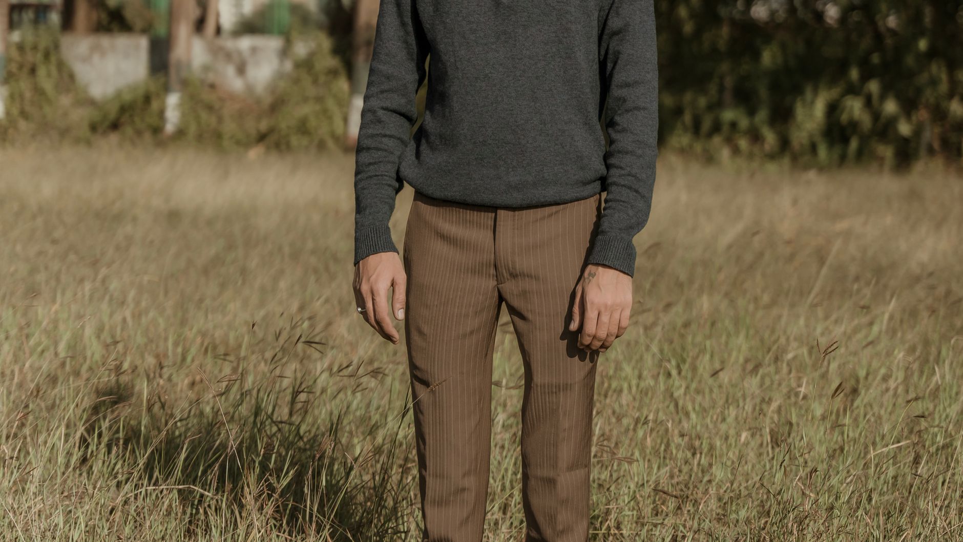 Navy knit polo with grey tailored trousers and white leather sneakers