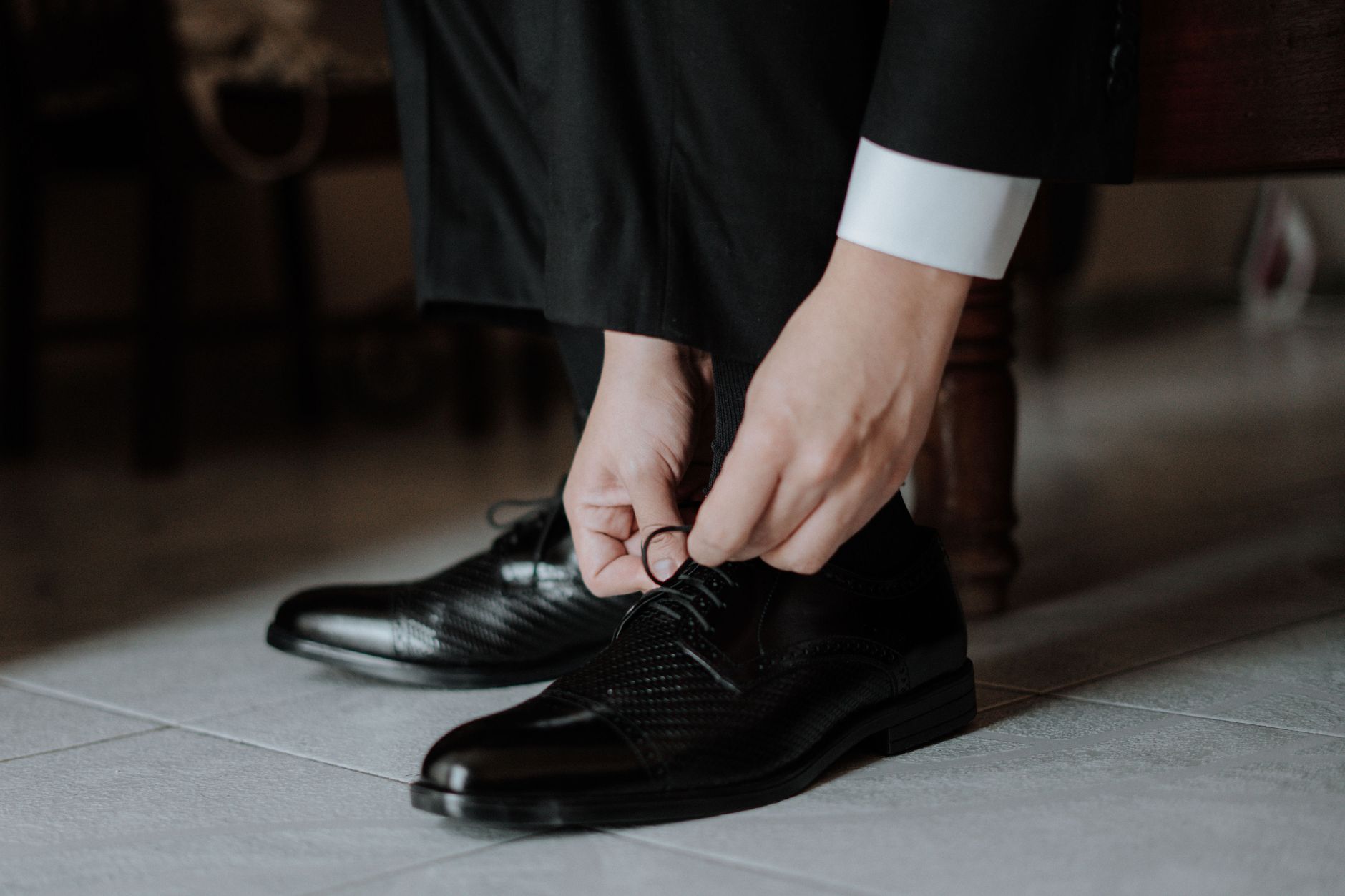 Suit trousers hemmed with a single break over polished leather oxfords