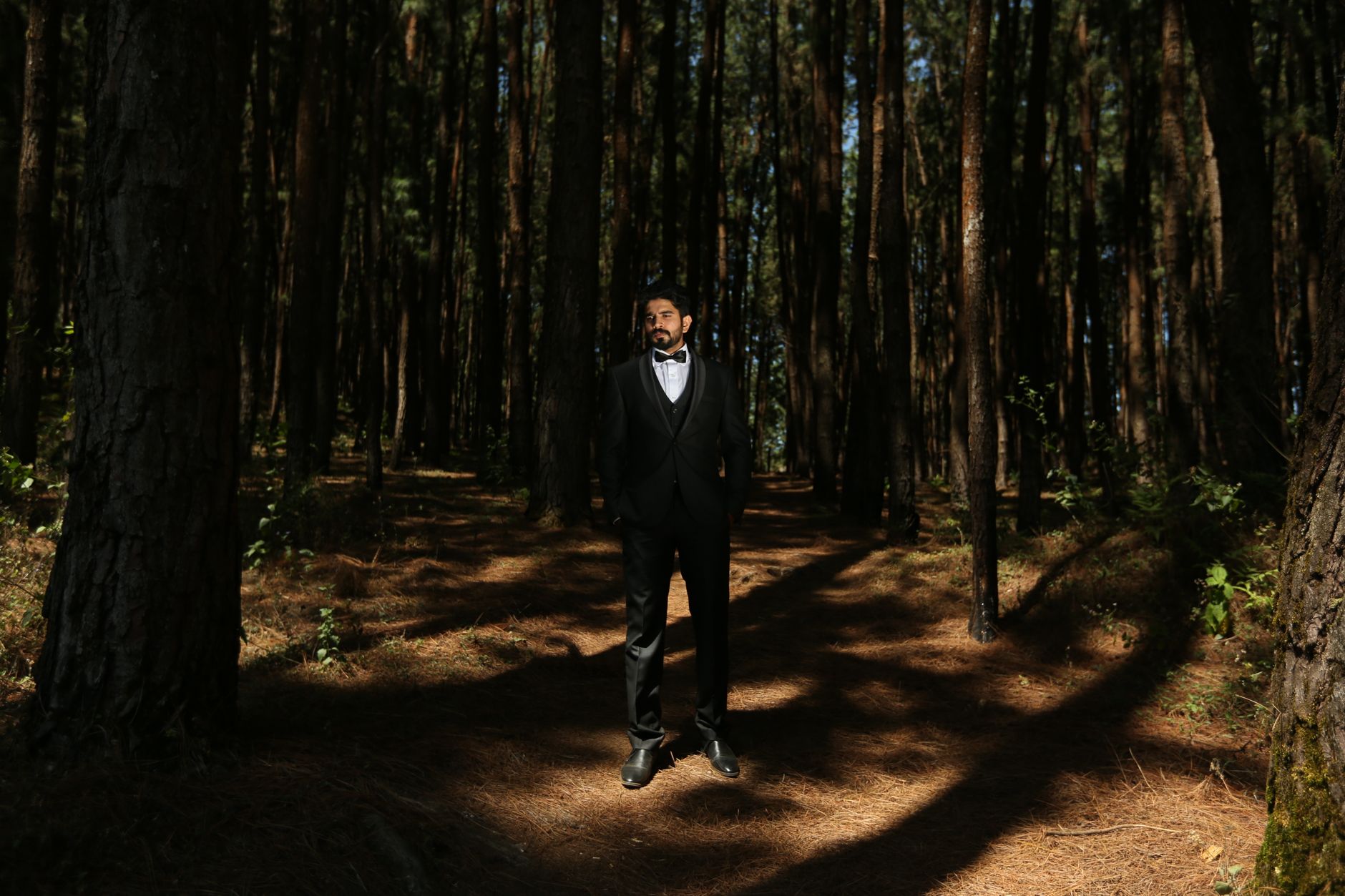 Wedding guest in a black tuxedo with a bow tie at an evening reception