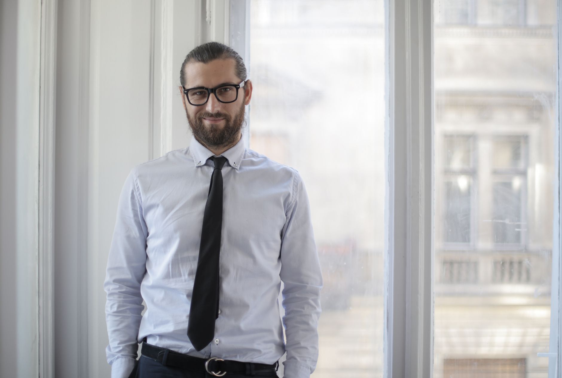 Man wearing navy chinos and a light blue oxford shirt in an office