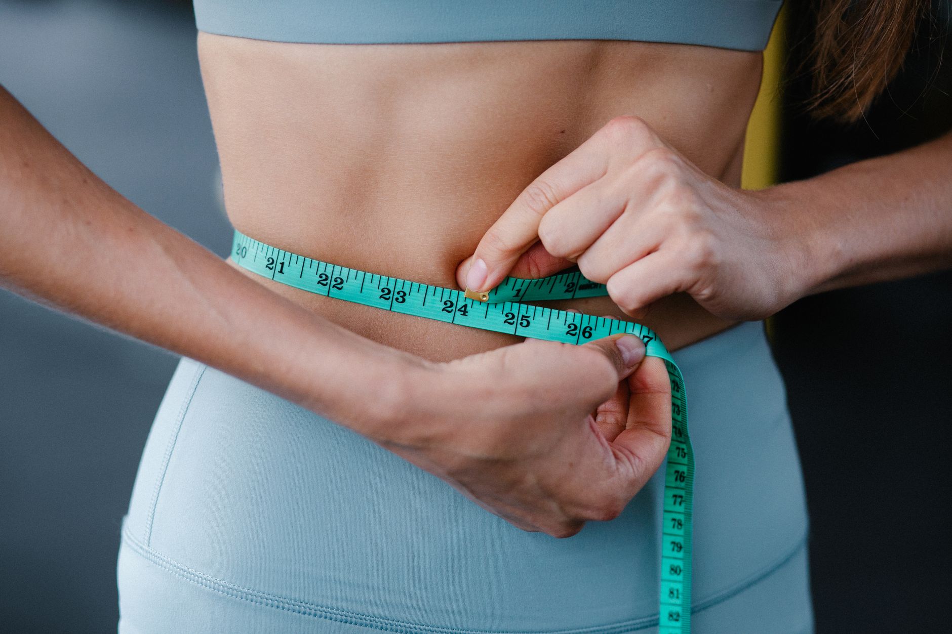 Measuring the waist with a tape measure to track results